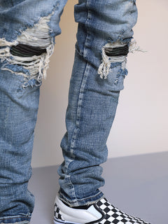 Men's ripped washed blue denim jeans with distressed details, casual fit, and classic five-pocket design.