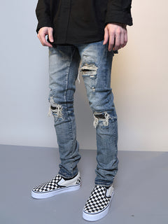 Men's ripped washed blue denim jeans with distressed details, casual fit, and classic five-pocket design.