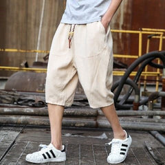 Men's casual loose linen cropped pants with a relaxed fit, light fabric, and neutral color, perfect for summer wear.