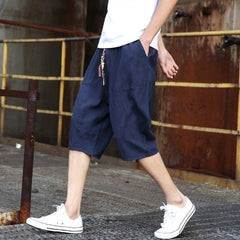Men's casual loose linen cropped pants in light fabric, featuring a relaxed fit and neutral color, ideal for comfortable summer wear.